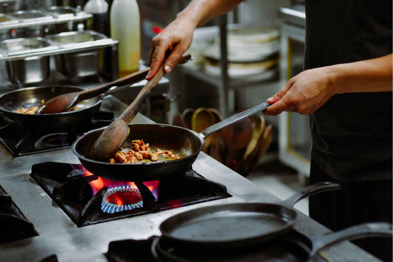 飲食店の厨房で調理するスタッフ